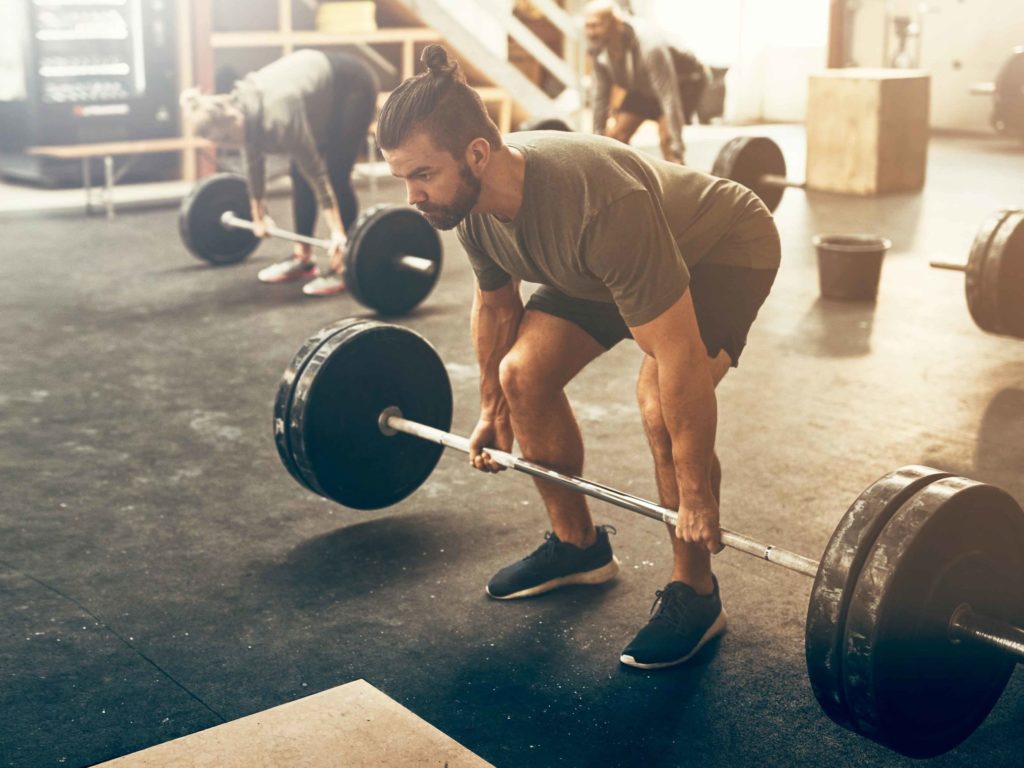 Man lifting a barbell doing a strength and muscle workout