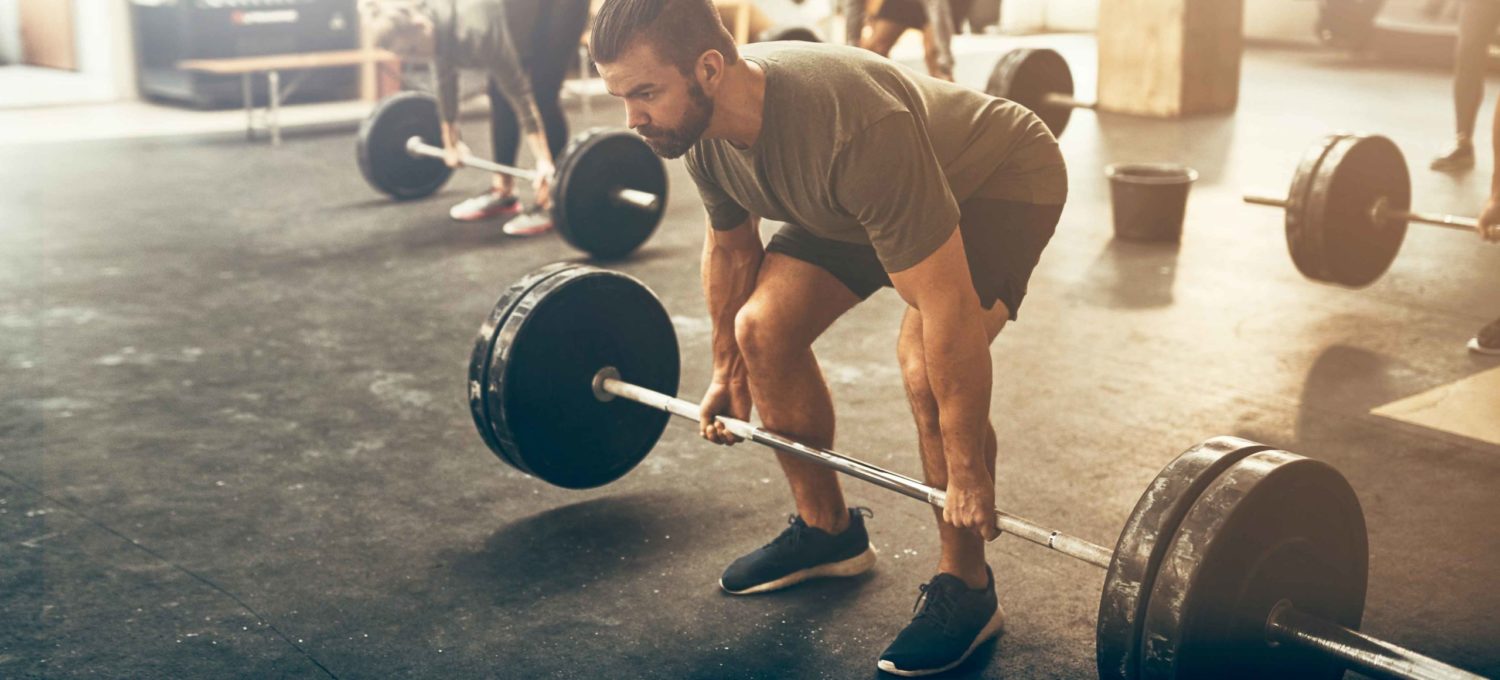 Man lifting a barbell doing a strength and muscle workout