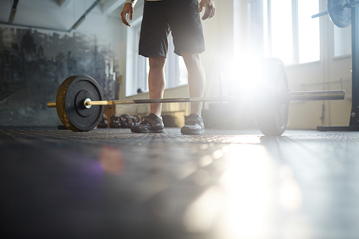 Man in gym with barbell reverse curl bicep forearm strenght size