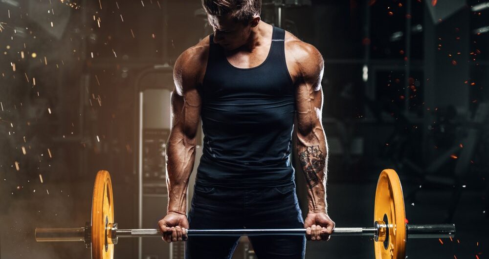 Man in gym biceps barbell curl strength muscle training